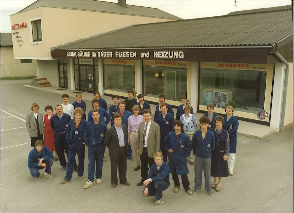 Gruppenfoto vor dem Schauraum mit der Aufschrift Schauräume für Bäder Fliesen und Heizung