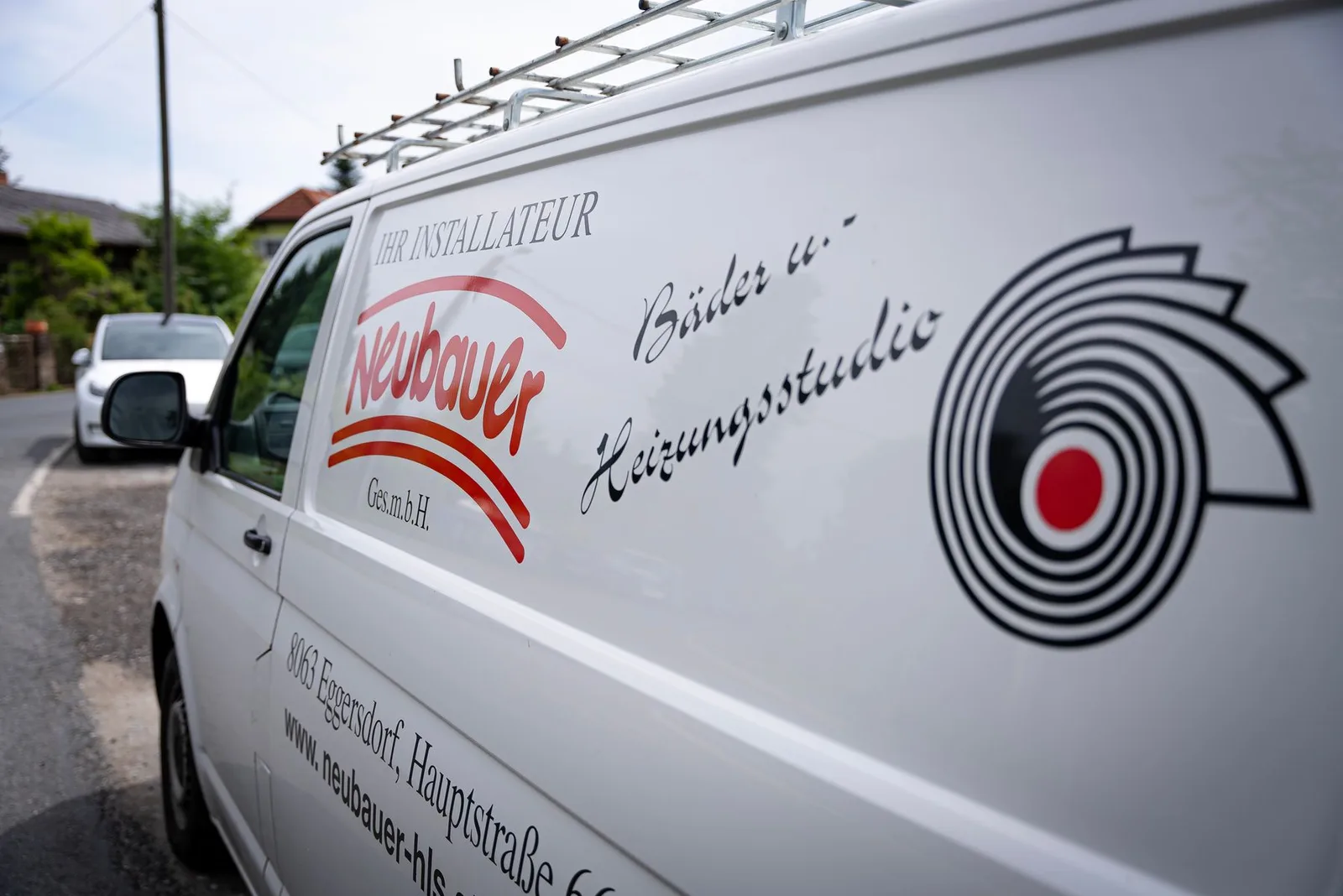 Weißer Firmenbus mit Neubauer-Logo und der Aufschrift Bäder u. Heizungsstudio
