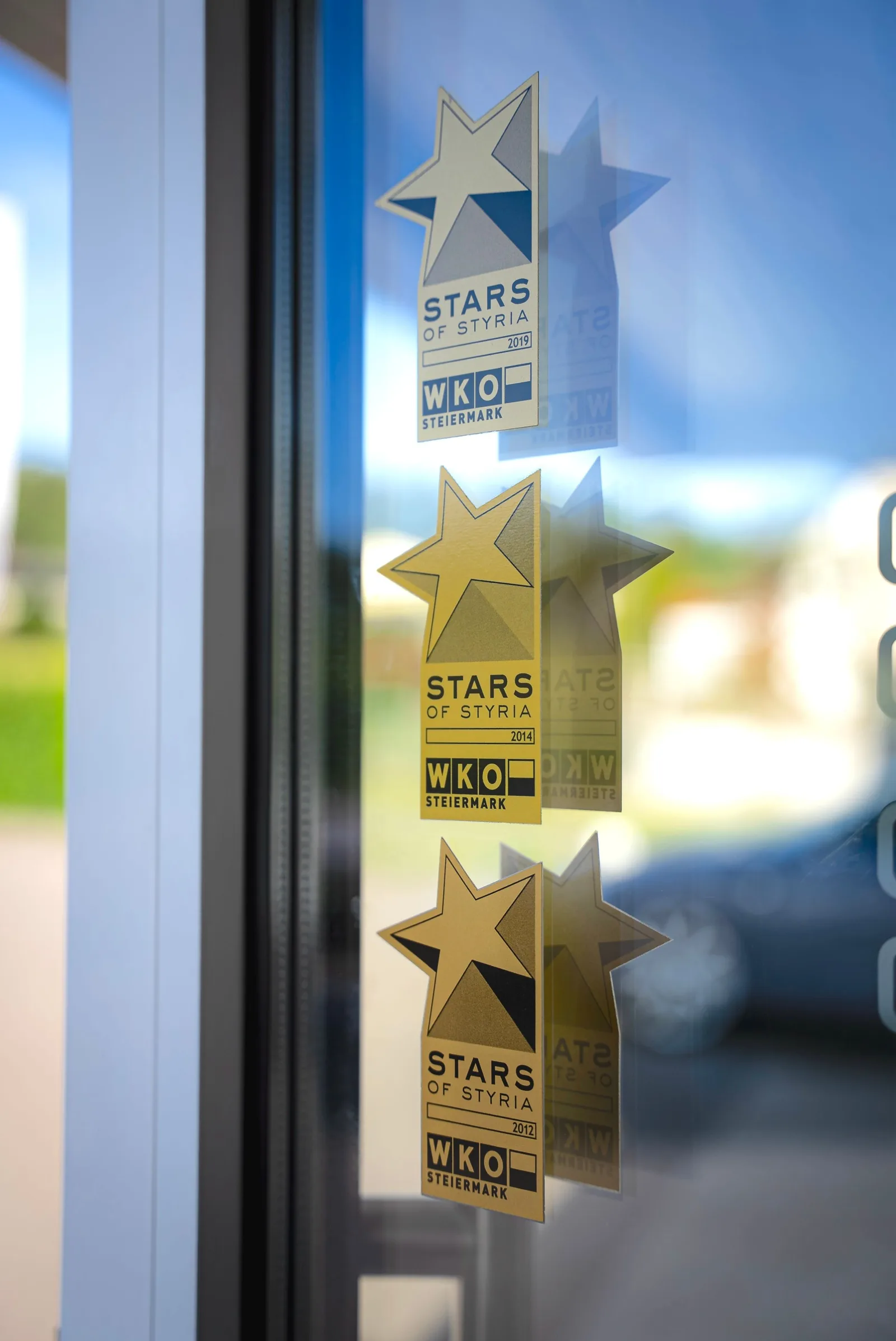 Drei Aufkleber Stars of Styria der WKO Steiermark an einer Glastür